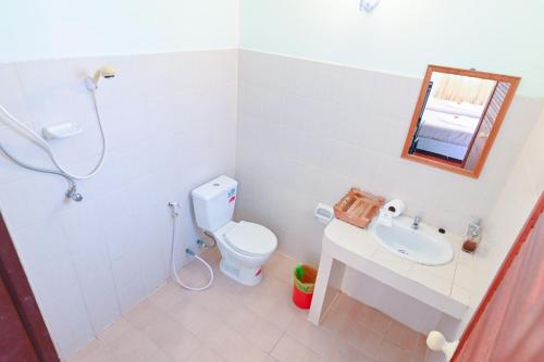a bathroom with a toilet and a sink and a mirror at Krathom Khaolak Resort in Khao Lak