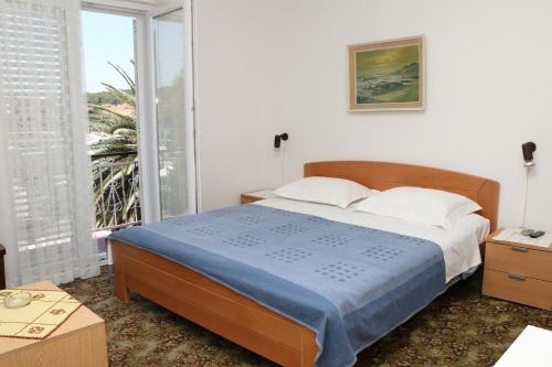sypialnia z łóżkiem i dużym oknem w obiekcie Apartman Mary Studio w mieście Kukljica