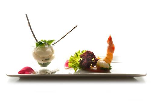 a plate of food on a table with a drink at Hotel Restaurant Kirchsteiger in Vollan