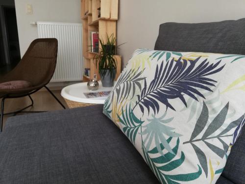 a bed with a pillow on it with a chair at appartement oostende vlak bij zee in Ostend