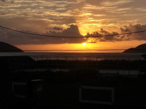 a sunset over a body of water with the sun setting at Pousada Recanto Verdes Mares in Arraial do Cabo