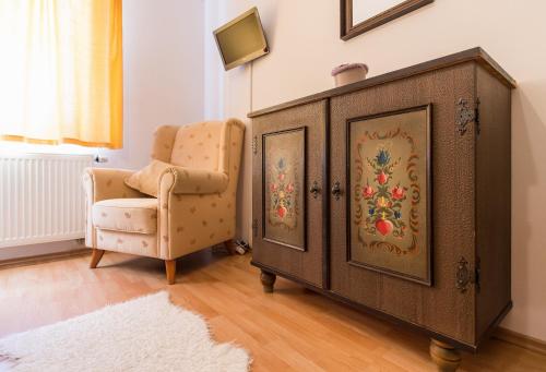 a chair and a dresser in a room at Pension Fialka in Český Krumlov