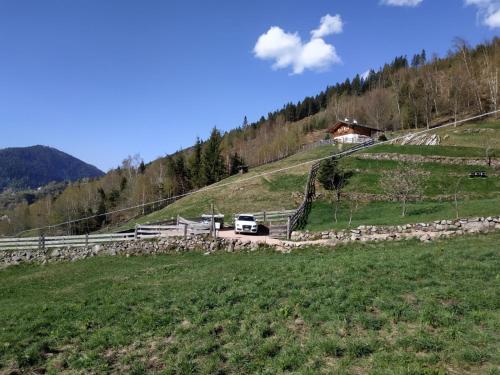 a truck driving down a hill in a field at Baita del Nonno dei Pitoi in Bedollo