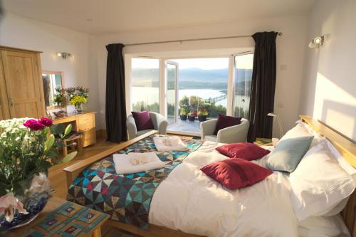 a bedroom with a large bed with pillows on it at Seascape at coed y berclas in Llandegfan