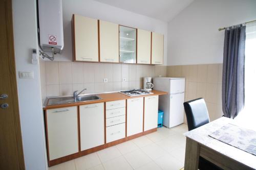a kitchen with white cabinets and a sink and a refrigerator at Sebi Apartment 300 m from beach in Rovinj