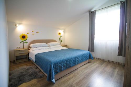a bedroom with a bed with a blue blanket and a window at Sebi Apartment 300 m from beach in Rovinj