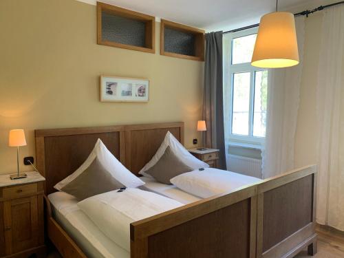 1 dormitorio con 1 cama con 2 almohadas blancas en Moselland Hotel im Enderttal Zum Onkel Willi, en Cochem