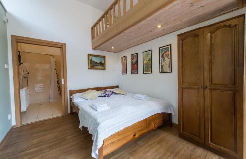 a bedroom with a bed and a wooden closet at Pension Fialka in Český Krumlov