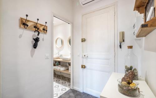 a white bathroom with a mirror and a sink at Hyper centre cannes 180 mètres plage in Cannes
