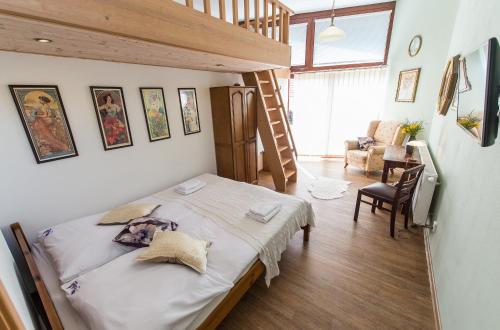 a small bedroom with a bed and a staircase at Pension Fialka in Český Krumlov