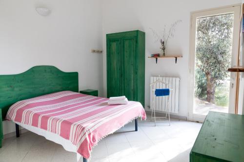 a bedroom with a green bed and a green door at The Aia in Nardò