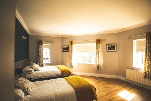 a bedroom with two beds and two windows at Kerrigan's B&B in Mullingar