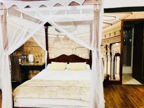 a bedroom with a bed with a canopy at Oldlands Farmhouse Gatwick in Horley
