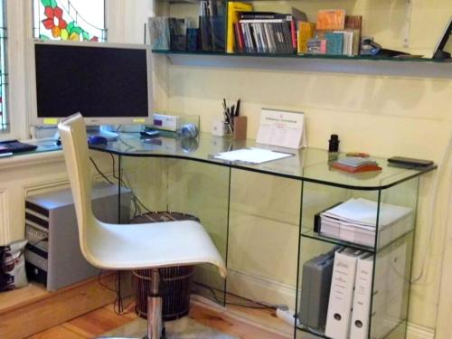 an office with a glass desk with a white chair at Apartment Alster in Hamburg