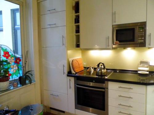 a kitchen with a stove and a microwave at Apartment Alster in Hamburg