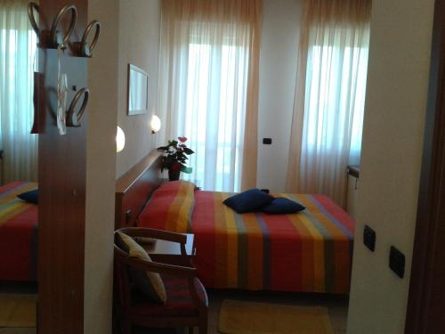 a bedroom with a bed with a colorful blanket at Hotel Garden Ristorante in Tabiano