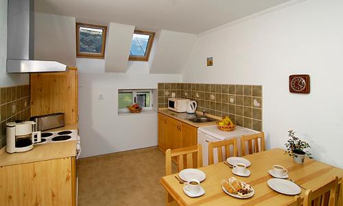 a kitchen with a wooden table and a kitchenasteryasteryasteryasteryasteryasteryastery at Päitara Hof in Mariánské Lázně