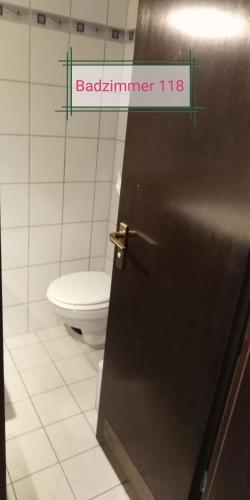 a bathroom with a toilet and a door with a sign at Sroom 118 and 119 in Center in Reutlingen