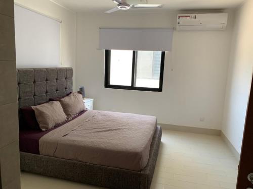 1 dormitorio con cama y ventana. en WATERFRONT FLAT en Sere Kunda NDing