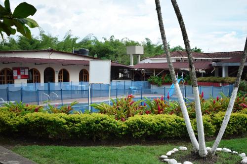 a building with a palm tree in front of a yard at Sede el Paraiso in Armenia