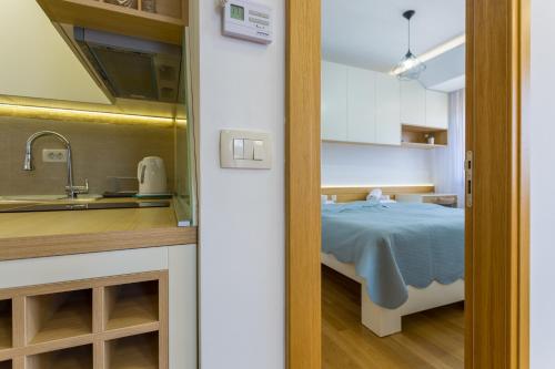 a room with a bed and a kitchen with a sink at Delights Apartment Zlatibor in Zlatibor