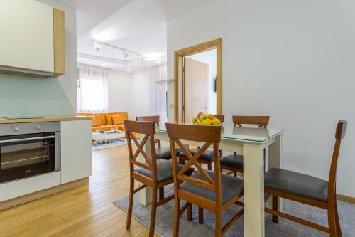 a kitchen and dining room with a table and chairs at Delights Apartment Zlatibor in Zlatibor
