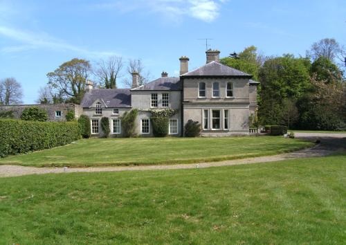 an old house with a large lawn in front of it at Gardenvale Manor House B&B in Stranocum