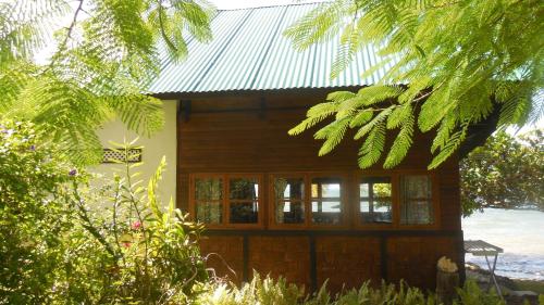 a log cabin with windows and a metal roof at Fare Vahine Oviri - 1048DTO-MT in Uturoa