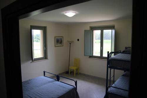 Cette chambre comprend 2 lits superposés et 2 fenêtres. dans l'établissement Fattoria Didattica Le Torte, à Bettona
