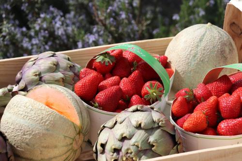 a box of strawberries and water melons on a table at La Cèzenole in Méjannes-le-Clap