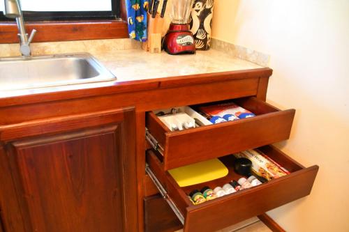 a kitchen counter with a sink and a drawer with spices at West Bay Lodge and Spa in West Bay