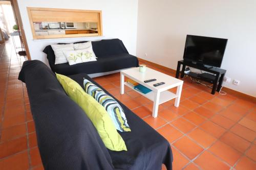a living room with a couch and a table at Casa S. José in Sesimbra