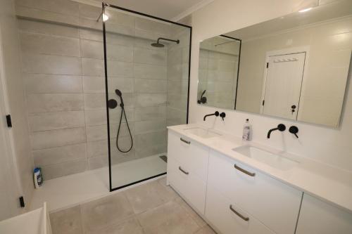 a bathroom with a shower and a sink and a mirror at Casa S. José in Sesimbra
