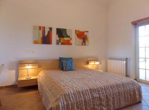 a bedroom with a large bed with two lamps on it at Praia Del Rey Beach Three Pools in Amoreira
