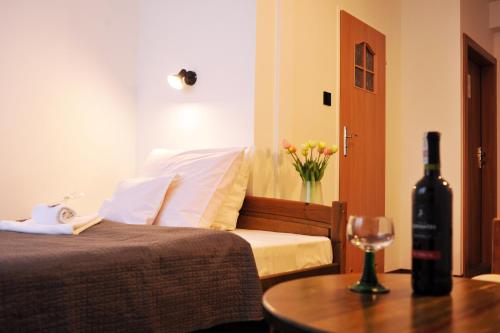 a bedroom with a bed and a bottle of wine at Hotel Protea Bolesławiec in Bolesławiec