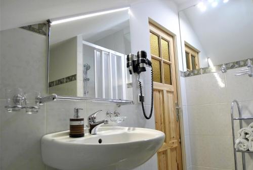 a bathroom with a white sink and a mirror at Hotel Protea Bolesławiec in Bolesławiec