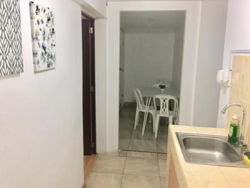 a kitchen with a sink and a table with chairs at Lima Mini Aparts Monterrico - Cerca Embajada EEUU in Lima