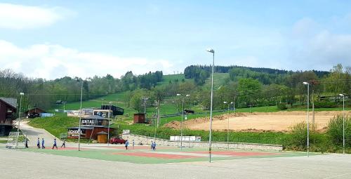 a group of people walking on a tennis court at Apartmán Alfa 11 in Cerny Dul
