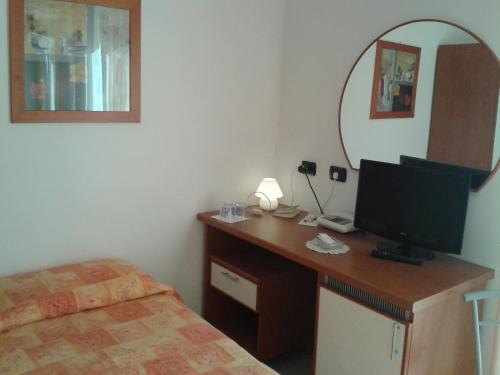 a bedroom with a desk with a television and a bed at Hotel Garden Ristorante in Tabiano