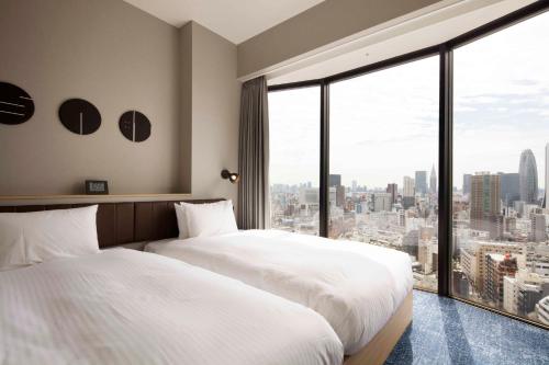 a hotel room with a large window overlooking the city at Hundred Stay Tokyo Shinjuku in Tokyo
