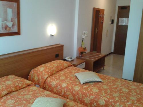 a hotel room with two beds and a table at Hotel Garden Ristorante in Tabiano