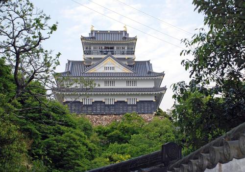 a large white building in the middle of trees at Hotel Sports Palko in Gifu