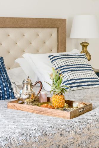 - un plateau avec un ananas et une bouilloire sur un lit dans l'établissement Résidence Saint-Sabin, à Paris