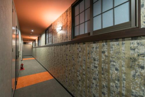 a corridor of a building with a wall of tiles at Stay SAKURA Kyoto Higashiyama Shirakawa in Kyoto