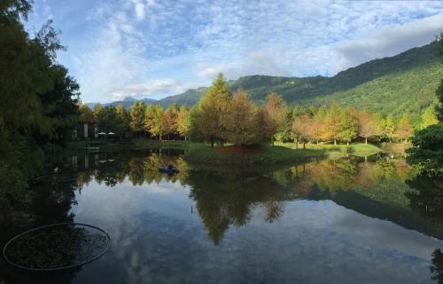 a view of a lake with trees and mountains at Grace Garden Villa in Fengshan