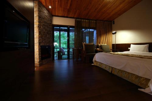 a bedroom with a bed and a fireplace and a television at Grace Garden Villa in Fengshan