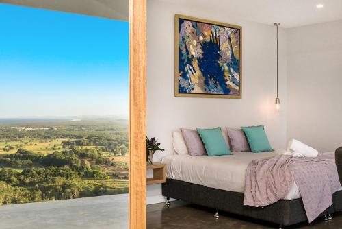 a bedroom with a bed and a painting on the wall at Sundays at Byron in Hayters Hill