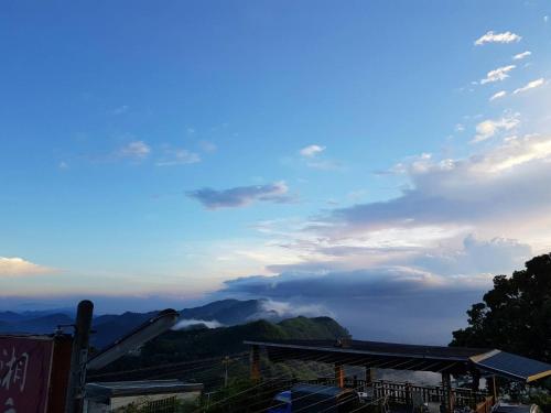 a view of a mountain with a blue sky and clouds at Ming Yang B&B in Fenchihu
