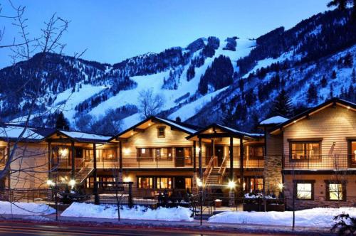 a lodge with snow covered mountains in the background at Innsbruck Aspen Deluxe One-Bedroom Garden Residence 1, Located on Main Street in Aspen