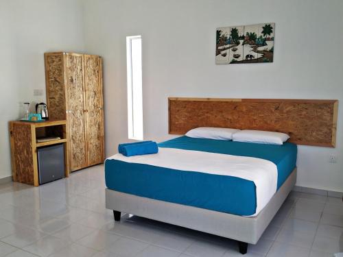 a bedroom with a large bed with blue and white sheets at Halcyon Days @ Langkawi in Pantai Cenang